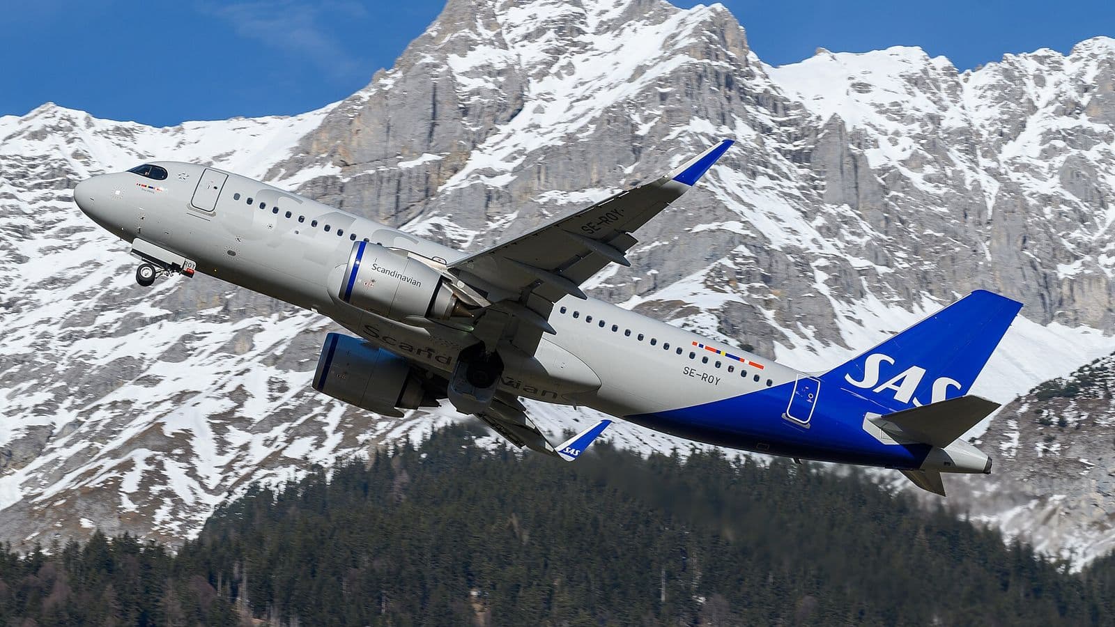 SAS Airbus A320neo climbing in front of snow-capped mountains