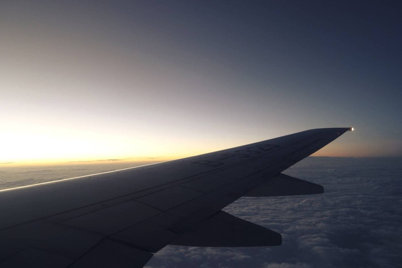 Aile d'un avion en vol à la tombée de la nuit